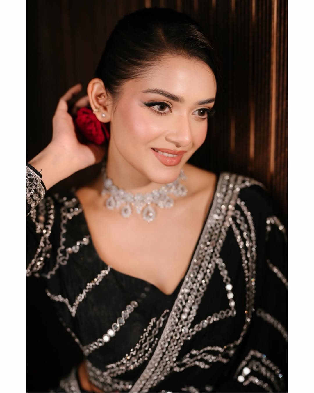 কানে লাল গোলাপ, মিষ্টি হাসি তার লুকে ক্লাসিক সৌন্দর্য এনেছে।