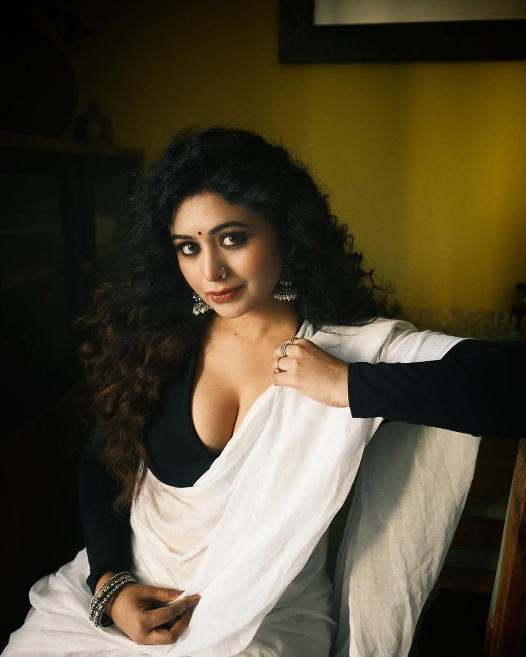 পরনে সুতি সাদা শাড়ির সঙ্গে ডিপ নেকলাইনের কালো ব্লাউজ।